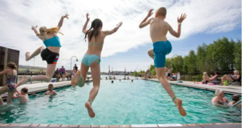 Barn som hoppar i en simbassäng